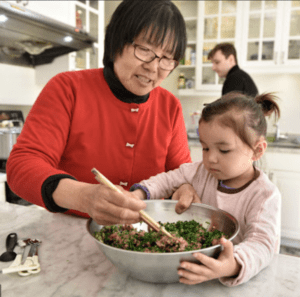 Asian Mom and a little one stir the pot
